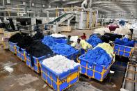 Workers sort washed and dyed garments stacked in carts at a textile factory of Texport Industries in Hindupur