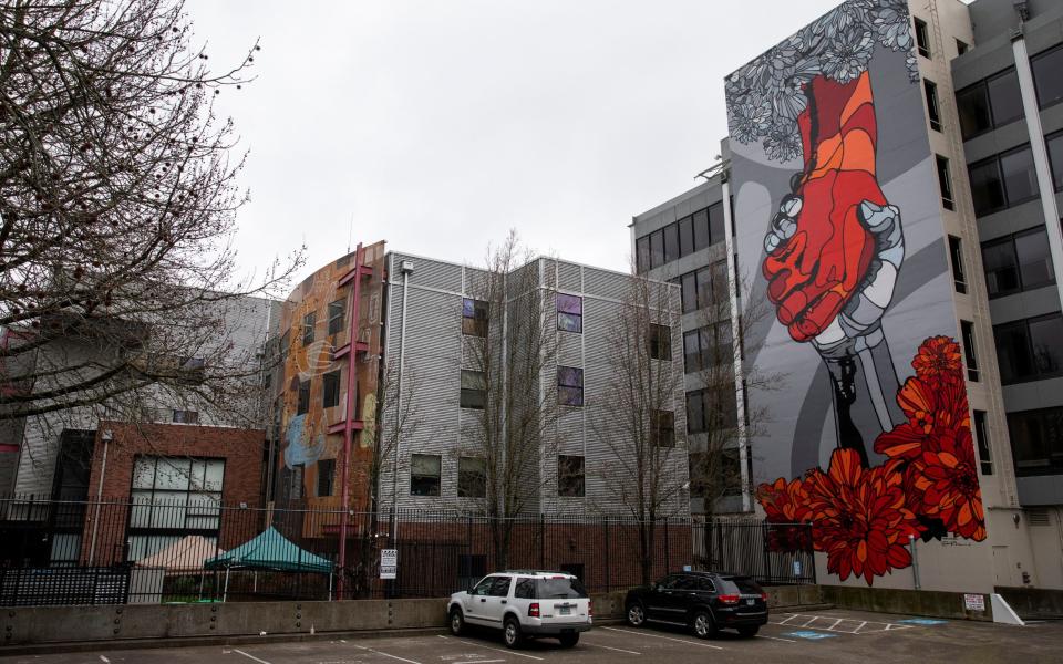 The Helping Hand mural by David Flores and Rudi Broschofsky is pictured behind Outside In in Portland Oregon  - ALISHA JUCEVIC 