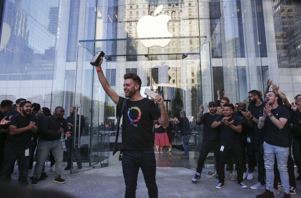 The first costumer to buy an iPhone 11 exits from the newly renovated Apple Store at Fifth Avenue on September 20, 2019 in New York City. (Photo by Kena Betancur / AFP)        (Photo credit should read KENA BETANCUR/AFP/Getty Images)