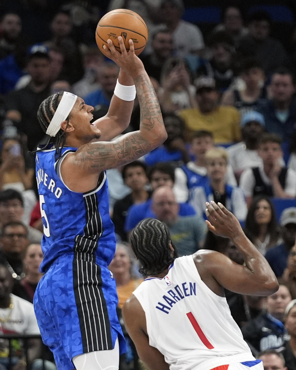 Orlando Magic forward Paolo Banchero, left, shoots over Los Angeles Clippers guard James Harden (1) during the second half of an NBA basketball game, Friday, March 29, 2024, in Orlando, Fla. (AP Photo/John Raoux)