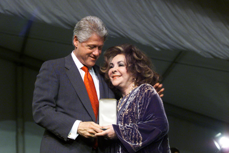 President Bill Clinton smiles at actress Elizabeth Taylor as (Harry Hamburg / Getty)