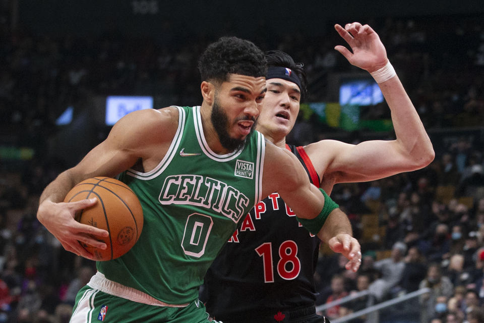 Boston Celtics' Jayson Tatum (0) drives past Toronto Raptors' Yuta Watanabe (18) during the first half of an NBA basketball game in Toronto, Sunday, Nov. 28, 2021. (Chris Young/The Canadian Press via AP)