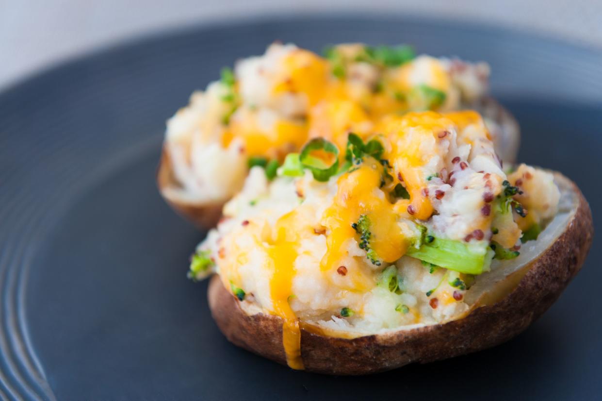 Broccoli and cheddar-stuffed potato skins with avocado cream on a steel blue plate