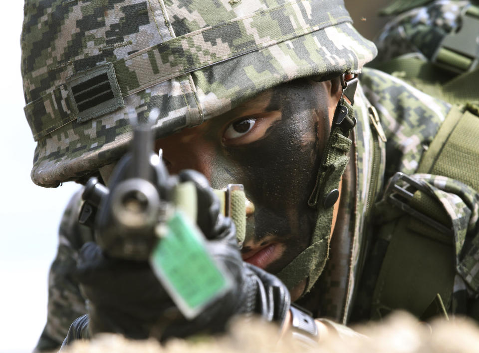 A South Korean marine aims his machine gun during the U.S.-South Korea joint landing exercises called Ssangyong, part of the Foal Eagle military exercises, in Pohang, South Korea, Monday, March 31, 2014. South Korea on Monday returned fire into North Korean waters after shells from a North Korean live-fire drill fell south of the rivals' disputed western sea boundary, a South Korean military official said. (AP Photo/Ahn Young-joon)