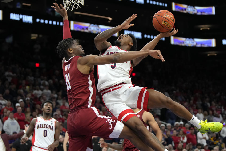 Arizona guard KJ Lewis (5) drives against Alabama forward Mohamed Wague during the first half of an NCAA college basketball game Wednesday, Dec. 20, 2023, in Phoenix. (AP Photo/Rick Scuteri)