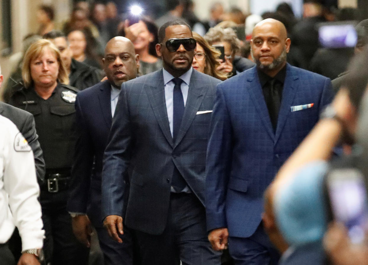 Three men have been arrested and charged for harassing alleged R. Kelly victims.