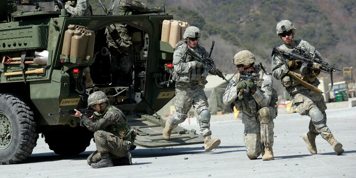 US Army soldiers from the 25th Infantry Division's 2nd Stryker Brigade Combat Team and South Korean soldiers take their position during a demonstration of the combined arms live-fire exercise