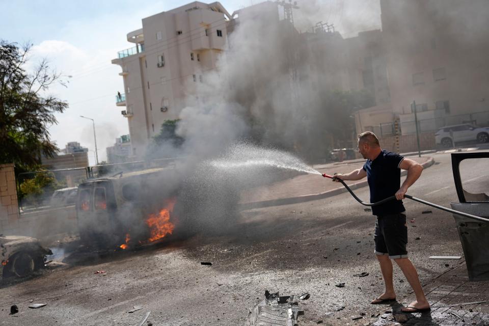 Cars are on fire after they were hit by rockets from the Gaza Strip in Ashkelon, Israel, on Saturday, Oct. 7, 2023. Palestinian militants in the Gaza Strip infiltrated Saturday into southern Israel and fired thousands of rockets into the country while Israel began striking targets in Gaza in response.