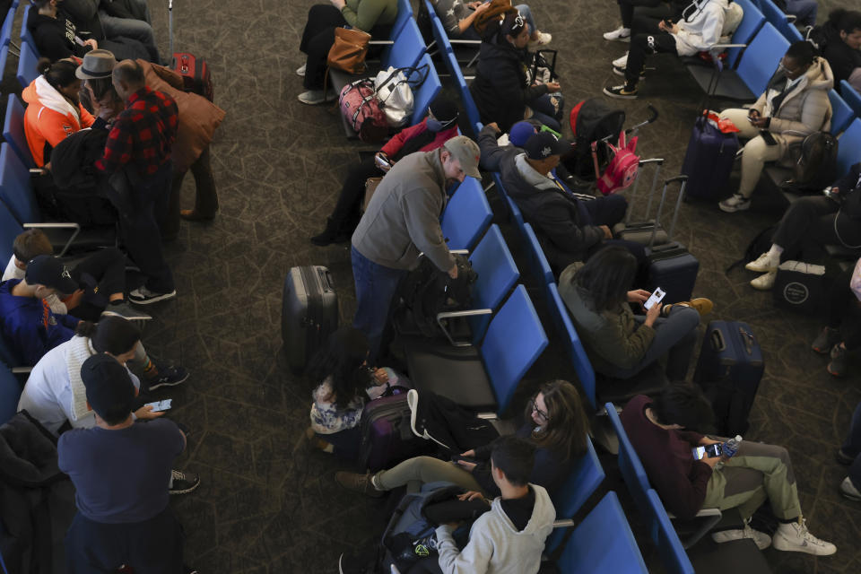 Travelers wait for boarding to begin in LaGuardia Airport's Terminal B, Tuesday, Nov. 22, 2022, in New York. Travel experts say the ability of many people to work remotely is letting them take off early for Thanksgiving or return home later. Crowds are expected to rival those of 2019, the last Thanksgiving before the pandemic. (AP Photo/Julia Nikhinson)