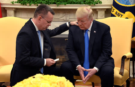 U.S. President Donald Trump closes his eyes in prayer along with Pastor Andrew Brunson, after his release from two years of Turkish detention, in the Oval Office of the White House, Washington, U.S., October 13, 2018. REUTERS/Mike Theiler