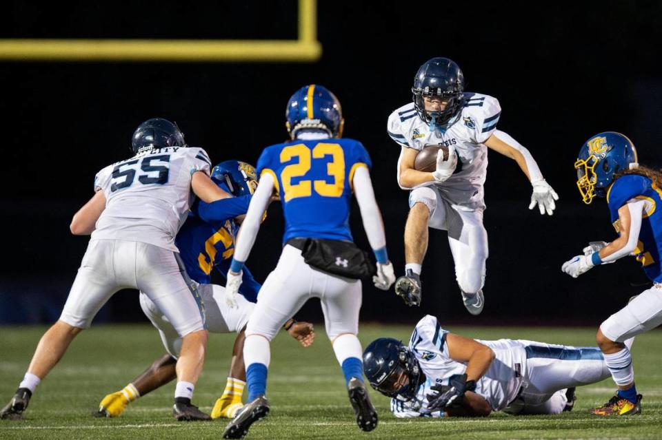 River City Raiders running back Vincent Alvarez (11) jumps over his teammate during the first half of the high school football game at Del Campo High School on Friday in Fair Oaks.