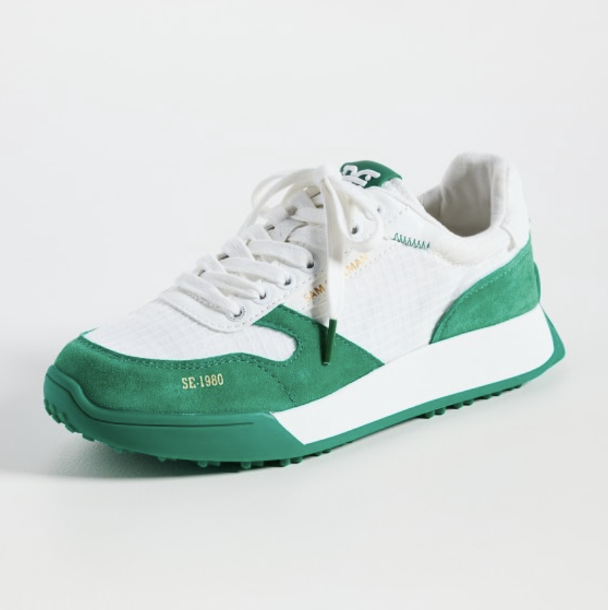 A white sneaker with green suede detailing