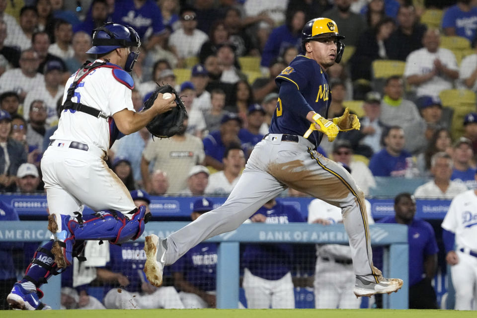 Los Angeles Dodgers catcher Austin Barnes, left, gets set to tag out Milwaukee Brewers' Tyrone Taylor after Taylor was caught between third and home on a fielders choice hit by William Contreras during the sixth inning of a baseball game Thursday, Aug. 17, 2023, in Los Angeles. (AP Photo/Mark J. Terrill)