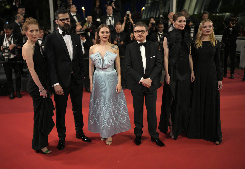 Orsolya Moldovan, from left, Marin Grigore, Macrina Barladeanu, director Cristian Mungiu, Judith State, and Maria Dragus pose for photographers upon arrival at the premiere of the film 'R.M.N.' at the 75th international film festival, Cannes, southern France, Saturday, May 21, 2022. (AP Photo/Daniel Cole)