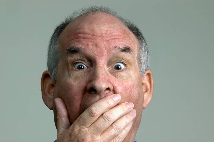 Close-up of older man covering his mouth in shock