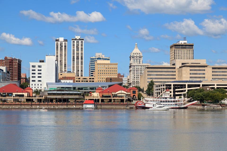 A skyline shows tall buildings along a river.