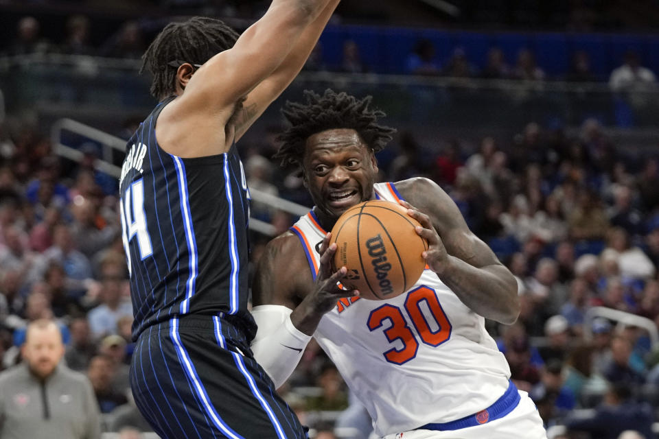 New York Knicks' Julius Randle (30) makes a move to the basket against Orlando Magic's Wendell Carter Jr., left, during the first half of an NBA basketball game Tuesday, Feb. 7, 2023, in Orlando, Fla. (AP Photo/John Raoux)