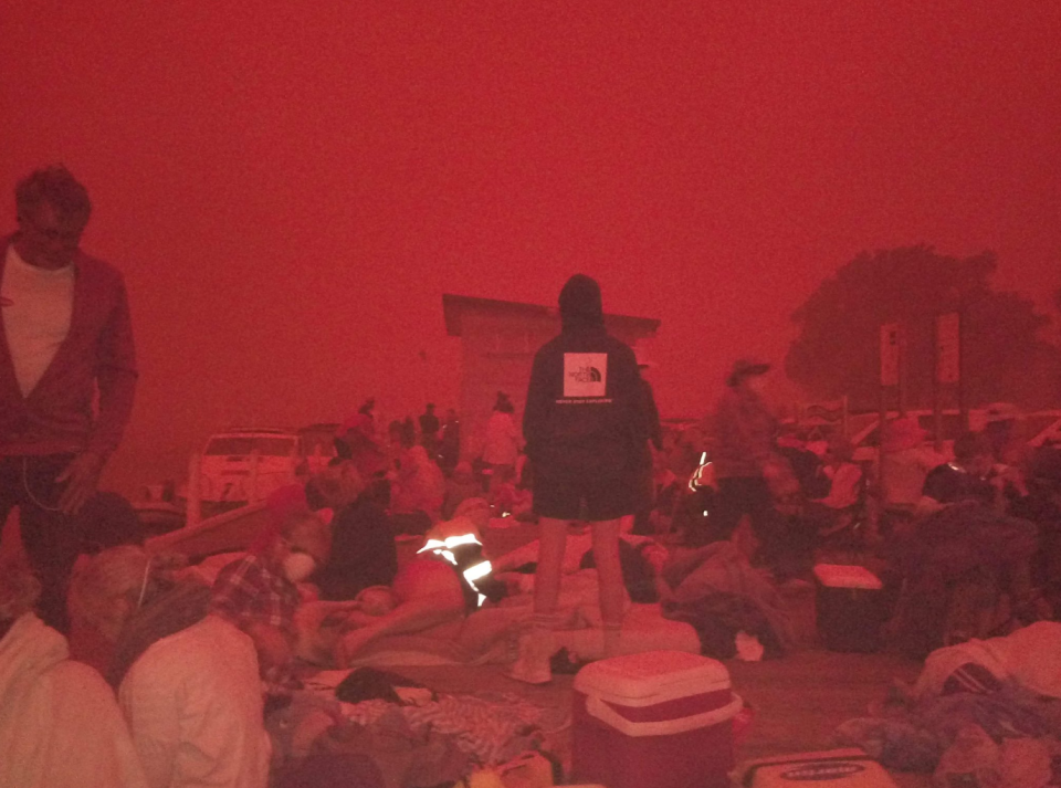 Pictured is Mallacoota residents on the shoreline on Tuesday amid the Victoria bushfires.