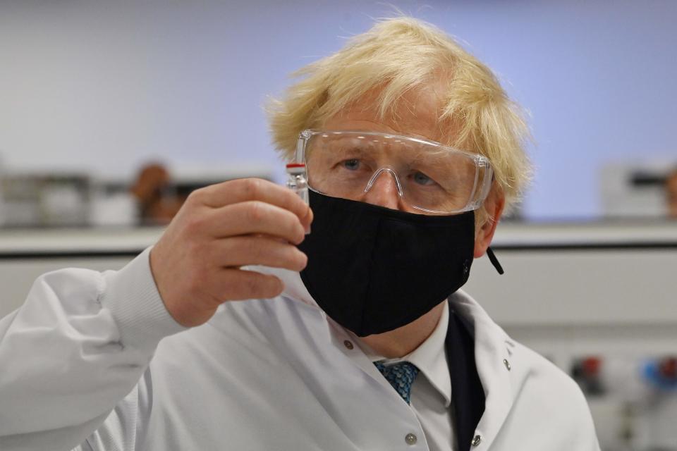 <p>Prime Minister Boris Johnson poses for a photograph with a vial of the AstraZeneca/Oxford University Covid-19 vaccine</p>POOL/AFP via Getty Images