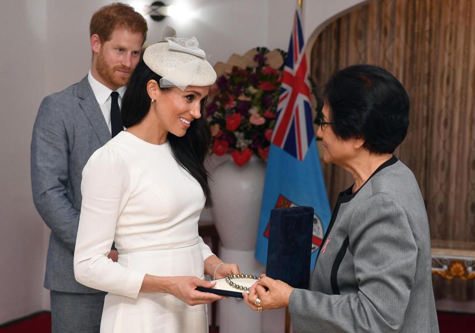 <p>Meghan receives a pearl necklace from Sarote Faga Konrote, the President's wife.</p>