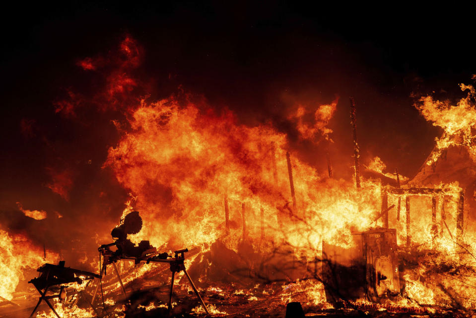 FILE - A structure is engulfed in flames as a wildfire called the Highland Fire burns in Aguanga, Calif., Oct. 30, 2023. The Biden administration is setting tougher standards for deadly soot pollution, saying that reducing fine particle matter from tailpipes, smokestacks and other industrial sources could prevent thousands of premature deaths a year. (AP Photo/Ethan Swope, File)