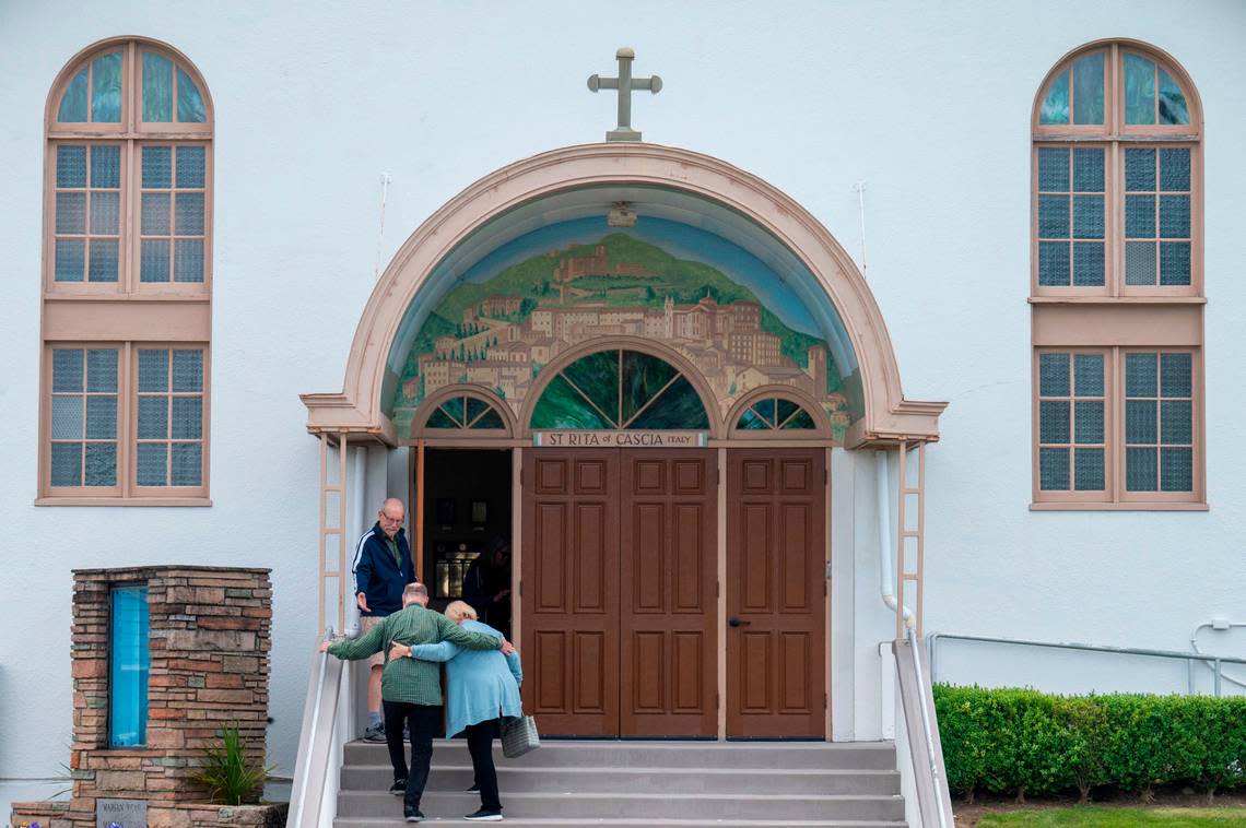 Parishioners at St. Rita of Cascia walk up the steps toward the church entrance for the final Mass before the church will be merged with several other small parishes in the area on Wednesday, June 8, 2022, in Tacoma.
