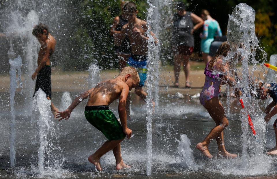 Children play in the fountain at Jordan Valley Park on Tuesday, July 19, 2022. Springfield saw record high temperatures that week.