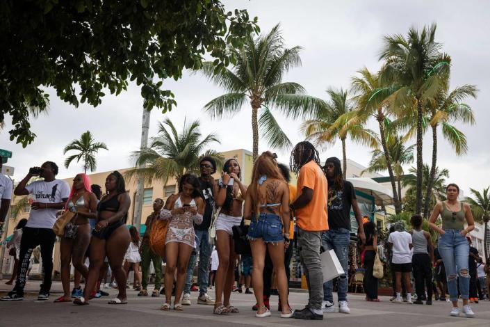 People gather outside of the Waldorf Towers Hotel on Sunday, March 19, 2023, on Ocean Drive in Miami.