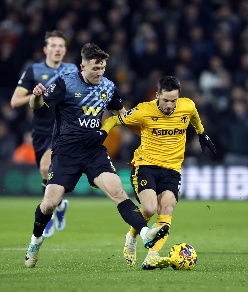 Burnley's Dara O'Shea and Wolverhampton Wanderers' Pablo Sarabia battle for the ball on during the English Premier League soccer match between Wolverhampton Wanderers and Burnley at Molineux Stadium, Wolverhampton, England, Tuesday, Dec. 5, 2023. (Mike Egerton/PA via AP)