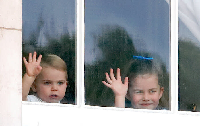 Prince Louis and Princess Charlotte wave from a window of Buckingham Palace during the Trooping The Colour.
