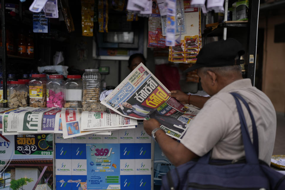 A man reads newspaper with news of Ranil Wickremesinghe's election in Colombo, Sri Lanka, Thursday, July 21, 2022. Sri Lanka's prime minister was elected president Wednesday by lawmakers who opted for a seasoned, veteran leader to lead the country out of economic collapse, despite widespread public opposition. (AP Photo/Rafiq Maqbool)