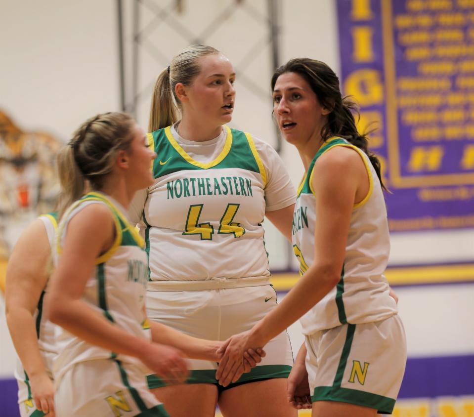 Northeastern sophomore Ava Mikesell (left) and juniors Addisen Mastriano (center) and Juztice Slick (right) high-five during a sectional game against Union County Feb. 3, 2023.