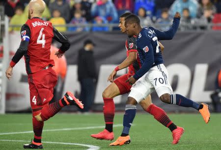 May 12, 2018; Foxborough, MA, USA; New England Revolution forward Cristian Penilla (70) scores a goal while Toronto FC midfielder Michael Bradley (4) looks on during the first half at Gillette Stadium. Mandatory Credit: Bob DeChiara-USA TODAY Sports