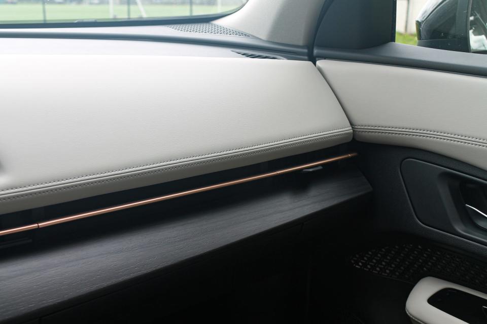 The white-leather dashboard of the Nissan Ariya, with faux-wood trim below.