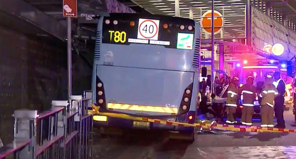 A bus crashed into the bus shelter on the intersection of Argyle and Church streets on Sunday night in Parramatta. Three 16-year-old girls were injured - one pinned underneath. Firefighters are seen next to the bus.