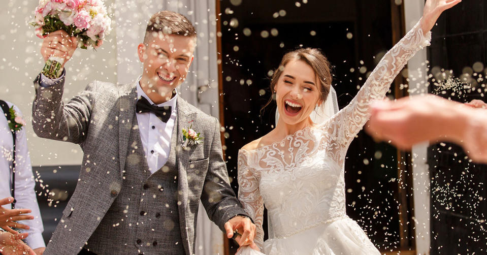A bride and groom at their wedding, with confetti flying in the air