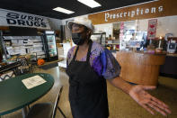 Co-owner of Creative Works Gallery and Cafe, Sarah Mayo, gestures during an interview in Surry, Va., Tuesday, Feb. 9, 2021. Mayo opened the cafe and gallery in an old pharmacy which closed. Mayo kept the pharmacy signs to remind people of what was there. (AP Photo/Steve Helber)