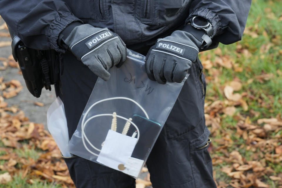 A Federal Police officer holds a bag with belongings of a migrant who illegally crossed the border from Poland into Germany during a patrol in a forest near Forst southeast of Berlin, Germany, Wednesday, Oct. 11, 2023. (AP Photo/Markus Schreiber)