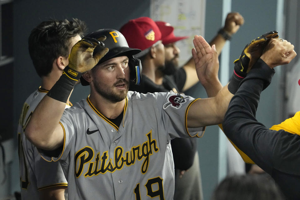 Pittsburgh Pirates' Jared Triolo is congratulated by teammates in the dugout after scoring on double by Josh Palacios during the ninth inning of a baseball game against the Los Angeles Dodgers Tuesday, July 4, 2023, in Los Angeles. (AP Photo/Mark J. Terrill)
