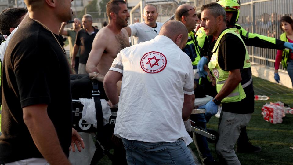 Emergency workers carry injured people on a stretcher