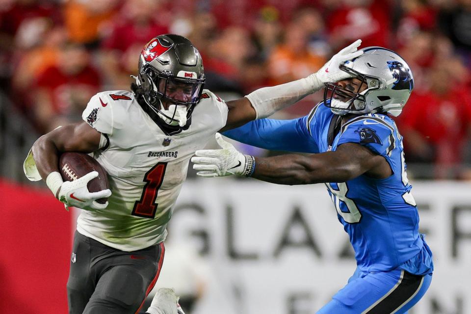 Tampa Bay Buccaneers running back Rachaad White (1) holds off Carolina Panthers linebacker Marquis Haynes Sr. (98) in the third quarter at Raymond James Stadium.