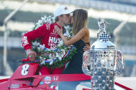 Marcus Ericsson, of Sweden, kisses girlfriend Iris Tritsaris Jondahl as they pose with the Borg-Warner Trophy during the traditional winners photo session at Indianapolis Motor Speedway in Indianapolis, Monday, May 30, 2022. Ericsson won the 106th running of the Indianapolis 500 auto race on Sunday. (AP Photo/Michael Conroy)