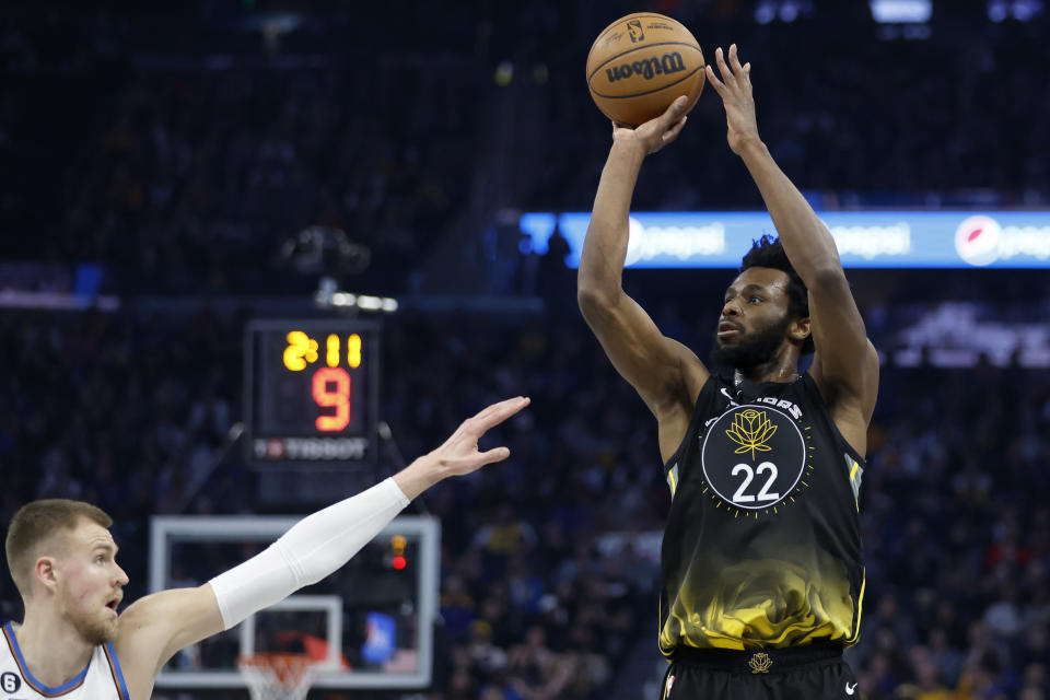 Golden State Warriors forward Andrew Wiggins (22) shoots against Washington Wizards center Kristaps Porzingis, left, during the first half of an NBA basketball game in San Francisco, Monday, Feb. 13, 2023. (AP Photo/Jed Jacobsohn)