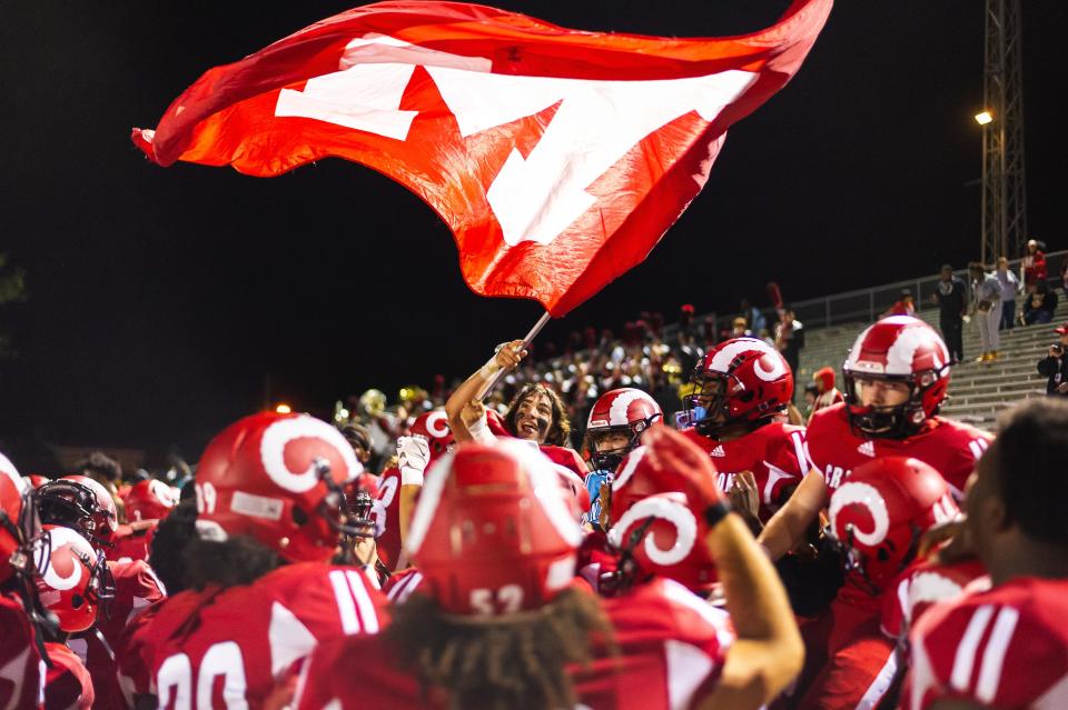 Members of Manual High School's football team celebrate a 21-0 win against Ballard on Friday, Sept. 23, 2022, in Louisville, Ky. The Crimsons improved to 6-0 with the victory.