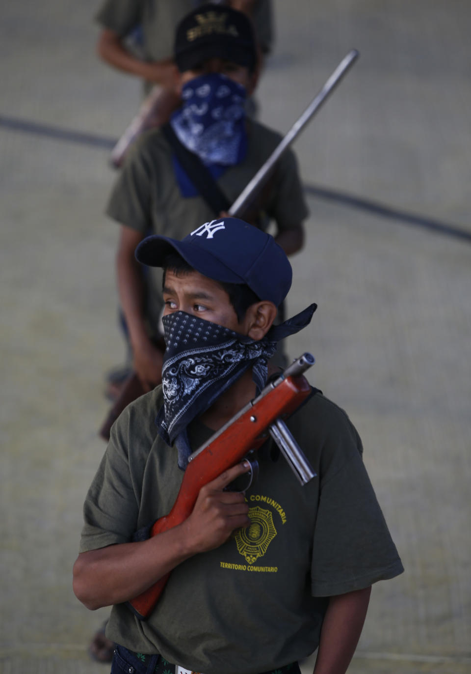 Children practice with weapons, some real and some fake, during a display for the media designed to attract the federal government's attention to the dangers of organized crime their town negotiates daily in Ayahualtempa, Guerrero state, Mexico, Wednesday, April 28, 2021. In Ayahualtempa, they plan to keep displaying armed children until they feel safe. (AP Photo/Marco Ugarte)