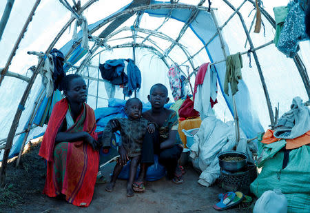 Mave Grace (R), 11, who had part of her arm chopped off by militiamen when they attacked the village of Tchee, sits in a tent with her aunt, Claudine Ngave (L), and her sister Racahele-Ngabausi, aged two, in an Internally Displaced Camp in Bunia, Ituri province, eastern Democratic Republic of Congo, April 12, 2018. REUTERS/Goran Tomasevic