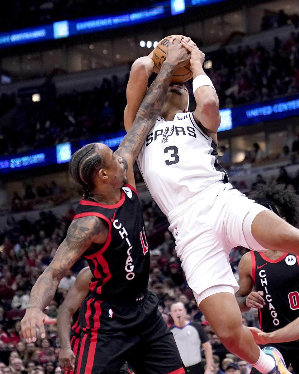 Chicago Bulls' DeMar DeRozan, left, blocks a shot by San Antonio Spurs' Keldon Johnson (3) during the first half of an NBA basketball game Thursday, Dec. 21, 2023, in Chicago. (AP Photo/Charles Rex Arbogast)