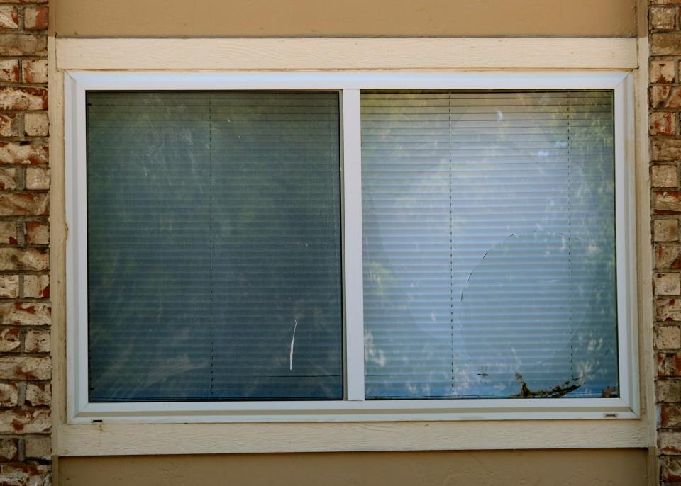 A broken window is seen at The Alora apartments.