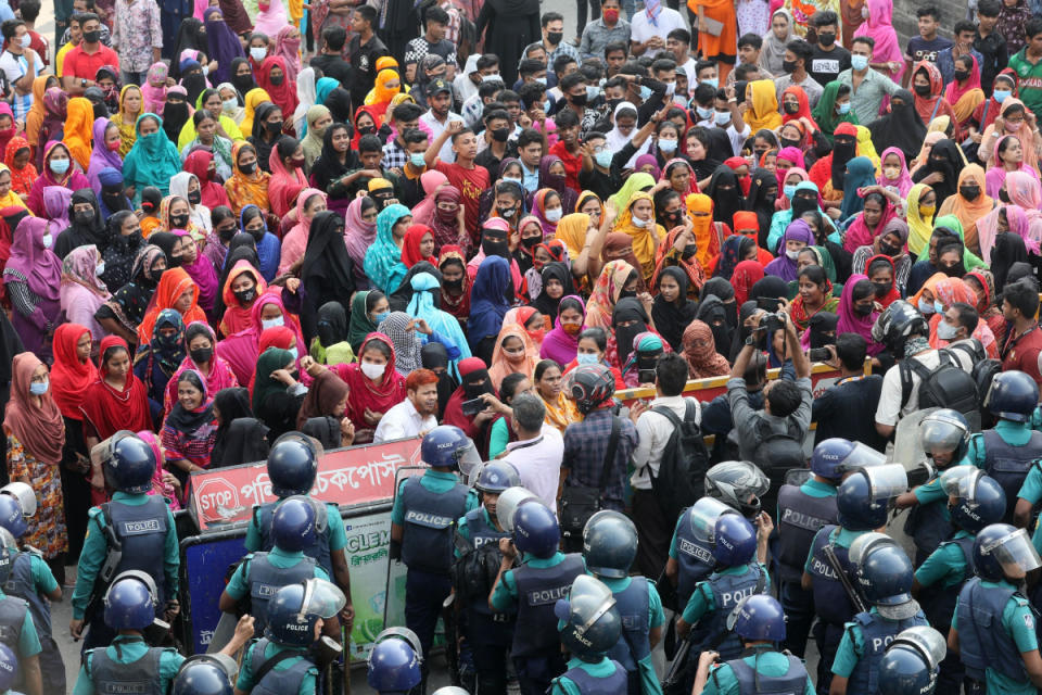 TOPSHOT - Garment workers block a key intersection as they protest in Dhaka on November 12, 2023, demanding a near-tripling of the minimum wage to 23,000 taka ($208). Hundreds of Bangladeshi garment workers rallied November 12 demanding fair wages after dismissing a pay offer as too small, as the death toll from the violent protests that erupted last month rose to four. (Photo by Abdul Goni / AFP) (Photo by ABDUL GONI/AFP via Getty Images)
