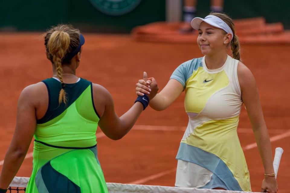 Amanda Anisimova shakes hands with Naomi Osaka after winning their first-round encounter.